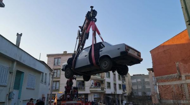 Satın aldığı klasik otomobili bulunduğu bahçeden vinç yardımıyla çıkardı